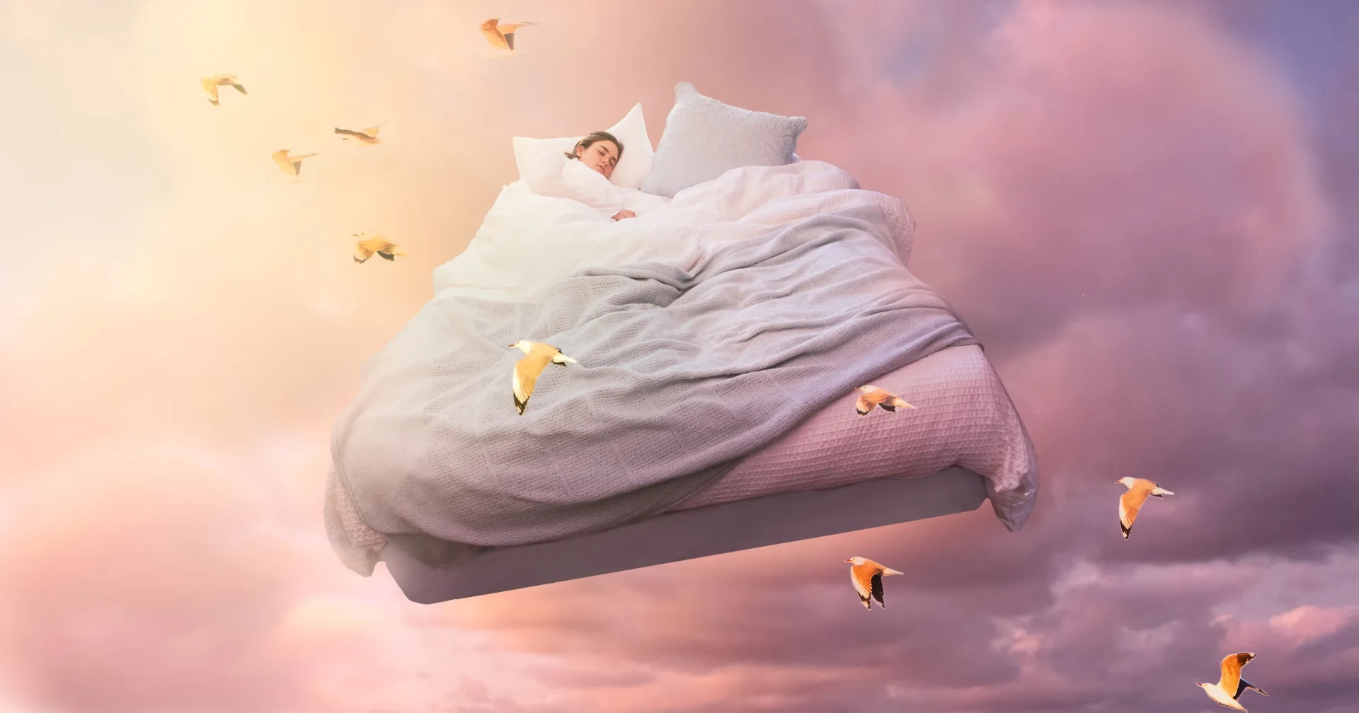 Schwebendes Bett unter weichem Abendhimmel mit Vögeln – Sinnbild für das Träumen vom Fliegen
