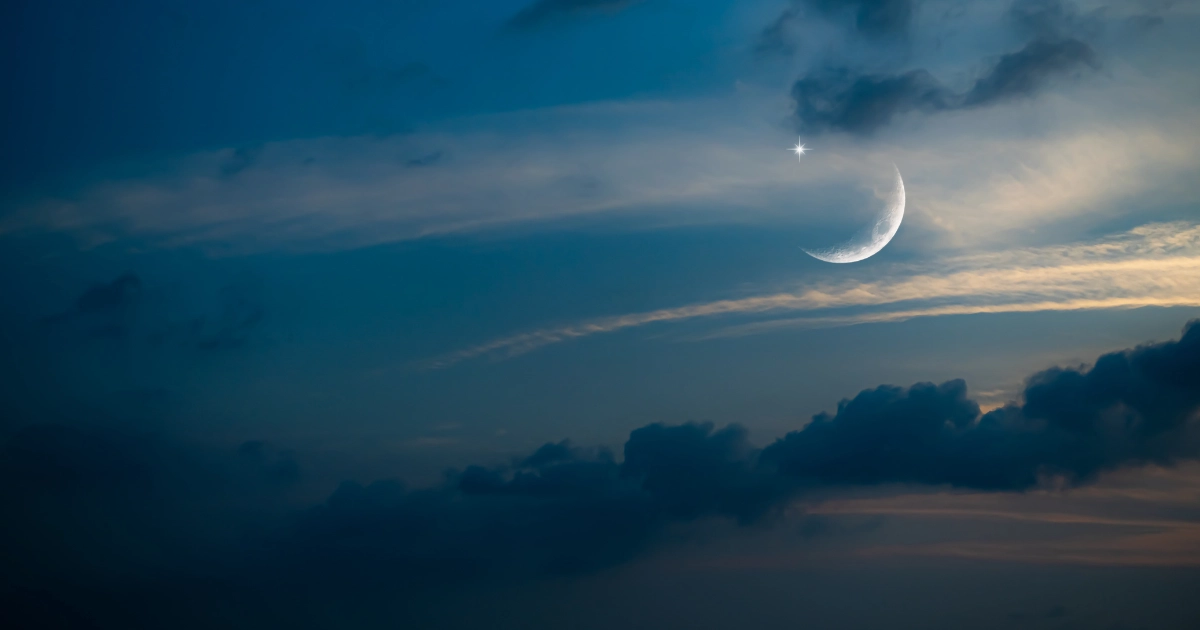 Waxing crescent moon with a star in the night sky – an image for dreaming about pregnancy